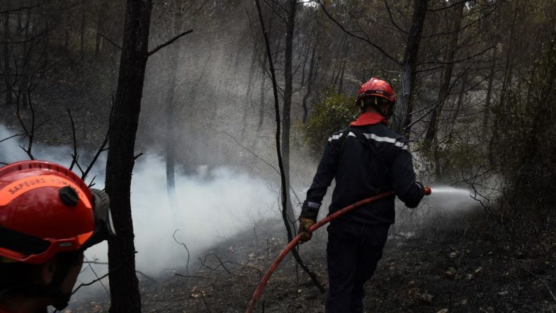 Les pompiers éteignent un incendie dans les Bouches-du-Rhône (Crédit photo BORIS HORVAT/AFP via Getty Images)