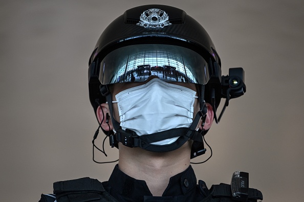 Un officier de police chinois monte la garde à l’aéroport international de Wuhan-Tianhe, dans la province du Hubei, le 8 avril 2020. Crédit : HECTOR RETAMAL/AFP via Getty Images.