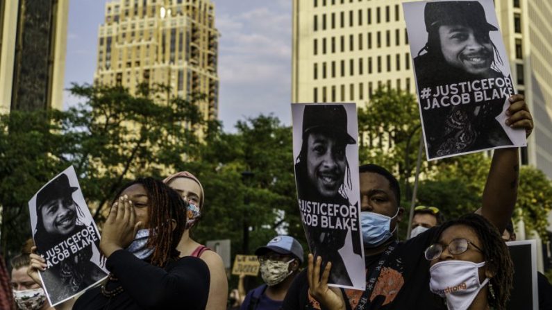 Des manifestants tiennent des pancartes devant le 1er commissariat de police de Minneapolis lors d'une manifestation contre la brutalité policière et le racisme à Minneapolis, Minnesota, le 24 août 2020. (Kerem Yucel/AFP via Getty Images)
