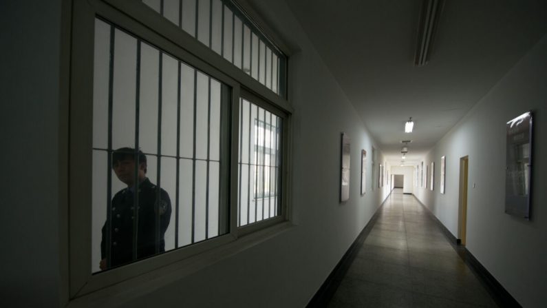 Un garde regarde par la fenêtre d'un couloir à l'intérieur du centre de détention n°1 lors d'une visite guidée du gouvernement à Pékin, en Chine, le 25 octobre 2012. (Ed Jones/AFP via Getty Images)