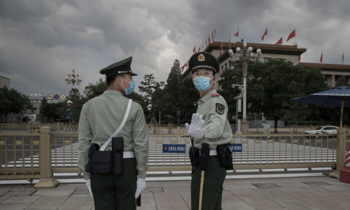 Des soldats de l'Armée populaire de libération empêchent un photojournaliste de prendre des photos sur la place Tiananmen, au Grand Hall du peuple à Pékin, le 25 mai 2020. (Andrea Verdelli/Getty Images)