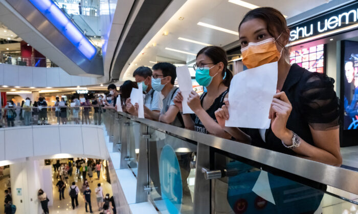 Le personnel de sécurité vérifie la température des personnes qui entrent dans un marché, tout en appliquant la distanciation sociale, à Penang, en Malaisie, le 29 mai 2020. (Goh Chai Hin/AFP via Getty Images)
