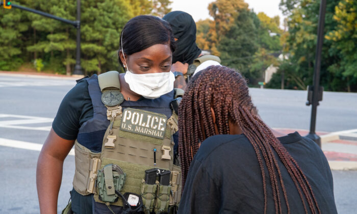 La photo montre un agent des forces de l'ordre du U.S. Marshals Service, qui participe à une mission sur les enfants disparus appelée "Opération Pas Oubliés" en août 2020. (Shane T. McCoy/US Marshals)