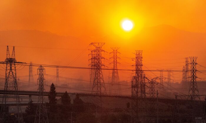 Le soleil se lève sur les lignes électriques le long d'un horizon enfumé lors de l'incendie de Saddleridge à Newhall, en Californie, le 11 octobre 2019. (Josh Edelson/AFP via Getty Images)