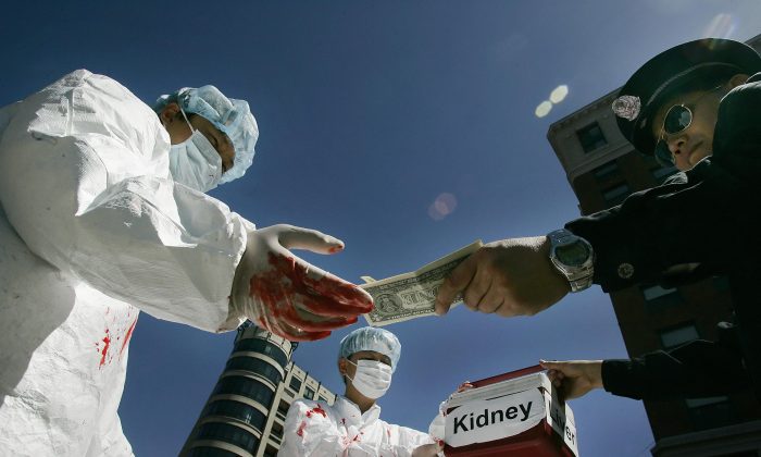 Des militants chinois mettent en scène un acte illégal de paiement d'organes humains lors d'une manifestation le 19 avril 2006 à Washington, D.C. (Jim Watson/AFP/Getty Images) 
