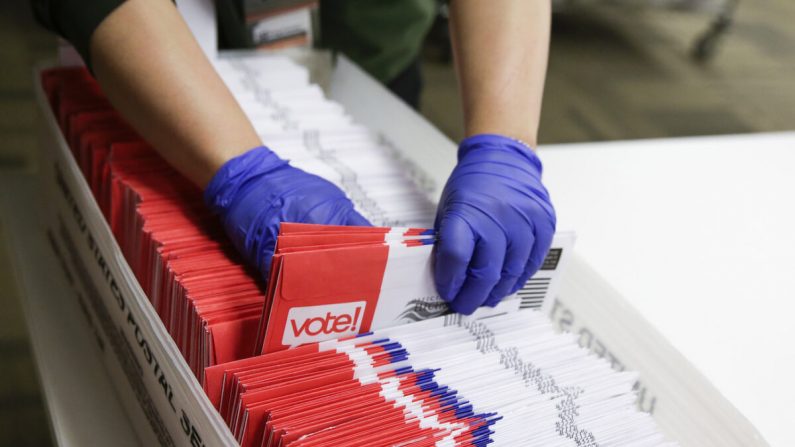 Un travailleur électoral trie des enveloppes de votes par correspondance pour les élections présidentielles primaires dans le comté de Renton, dans l'État de Washington, le 10 mars 2020, (Jason Redmond/AFP via GettyImages)