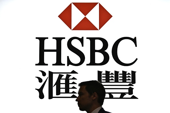 - Un homme passe devant un affichage rétroéclairé du logo HSBC à Hong Kong. Photo par Anthony WALLACE / AFP via Getty Images.