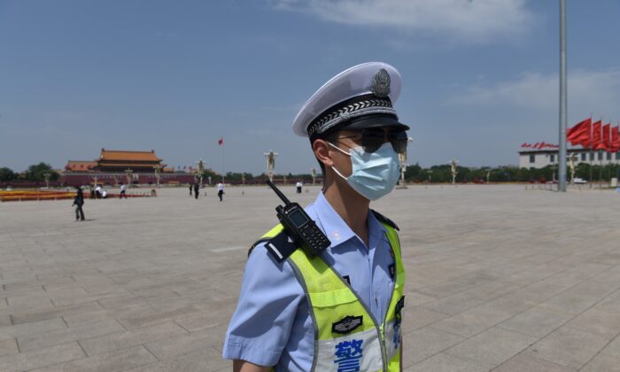 Un policier patrouille sur la place Tienanmen avant la séance de clôture de l'Assemblée populaire nationale dans la salle adjacente au Grand Hall du Peuple  à Pékin, le 28 mai 2020. (Nicolas Asfouri/AFP via Getty Images)