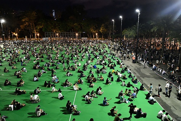 -Des militants tiennent un souvenir aux chandelles dans le parc Victoria à Hong Kong le 4 juin 2020. Une vingtaine de personnes arrêtées et poursuivies, jugées au tribunal de Hong Kong ce jour. Photo par Anthony WALLACE / AFP via Getty Images.