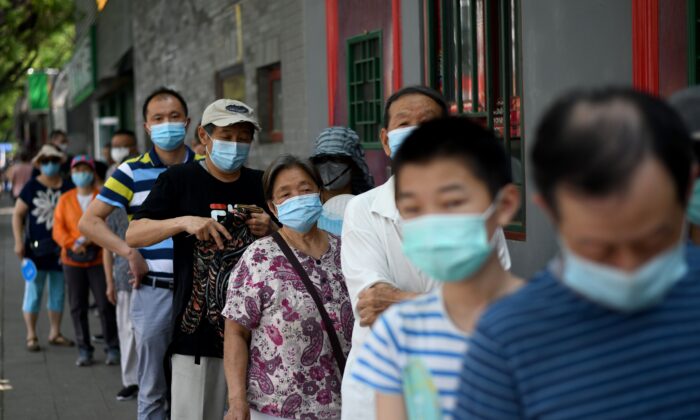 Des personnes font la queue pour passer un test par écouvillonnage lors d'un test de masse pour le coronavirus Covid-19 à Pékin, en Chine, le 21 juin 2020. (NOEL CELIS/AFP via Getty Images)