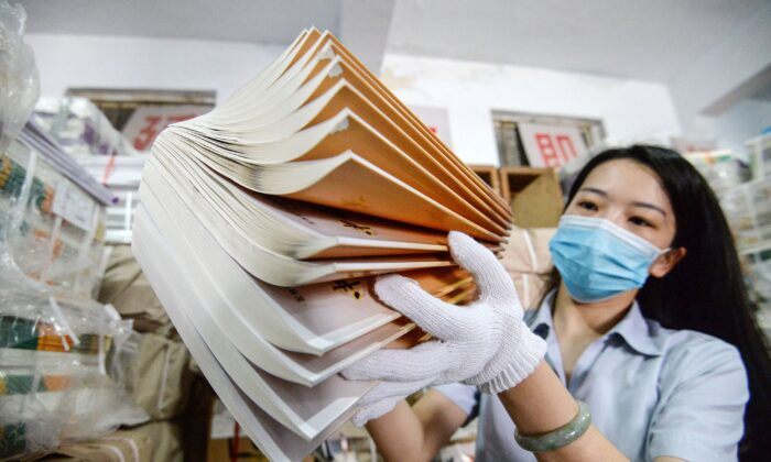 Une employée prépare des manuels scolaires dans une librairie avant le nouveau semestre scolaire, à Handan, dans la province de Hebei, au nord de la Chine, le 24 août 2020. (Photo par STR / AFP) / China OUT (Photo par STR/AFP via Getty Images)