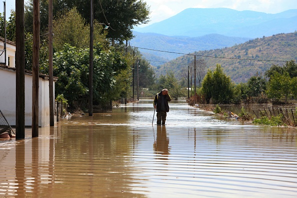 -Un homme marche dans une rue inondée du village de Magoula, dans le centre de la Grèce, le 19 septembre 2020. Photo par Kostas Mantziaris / AFP via Getty Images.