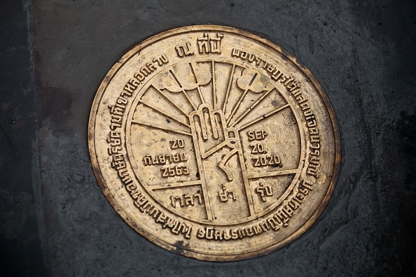 -Une plaque installée par des militants de Bangkok déclarant que la Thaïlande "appartient au peuple" a été enlevée le 21 septembre. Photo par Lillian SUWANRUMPHA et Jack TAYLOR / AFP via Getty Images.