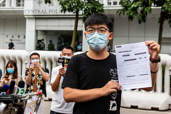 -Le militant Joshua Wong s'adresse aux médias tout en montrant un document de mise en liberté sous caution Hong Kong le 24 septembre 2020. Photo par Isaac Lawrence / AFP via Getty Images.