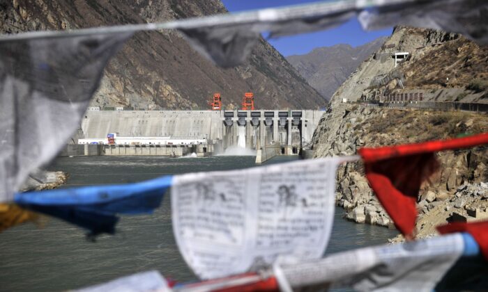 Cette photo prise le 23 novembre 2014 montre des drapeaux de prière accrochés devant la centrale hydroélectrique de Zangmu dans le comté de Gyaca à Lhoka, ou préfecture de Shannan, dans la région du Tibet au sud-ouest de la Chine. ( STR/AFP via Getty Images)