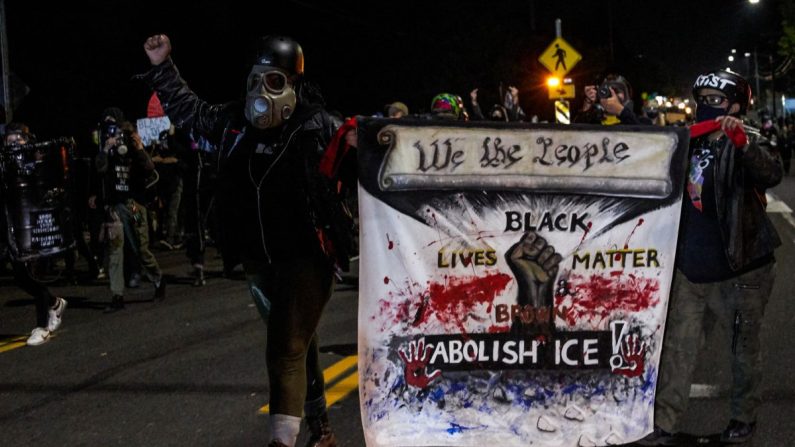 Des gens portent une bannière lors d'une marche qui s'est transformée en émeute à Portland, Oregon, à la fin de la journée du 5 septembre 2020. (Allison Dinner/AFP via Getty Images)