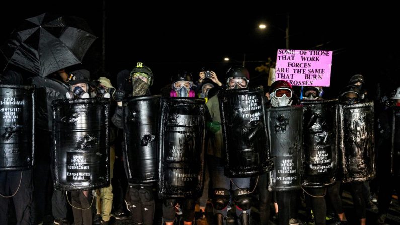 Des individus qui portent des boucliers sur lesquels est écrit « Abolissez le PPB », ou la police, au cours d'une manifestation qui s'est transformée en émeute à Portland, Oregon, à la fin de la journée du 5 septembre 2020. (Allison Dinner/AFP via Getty Images) 