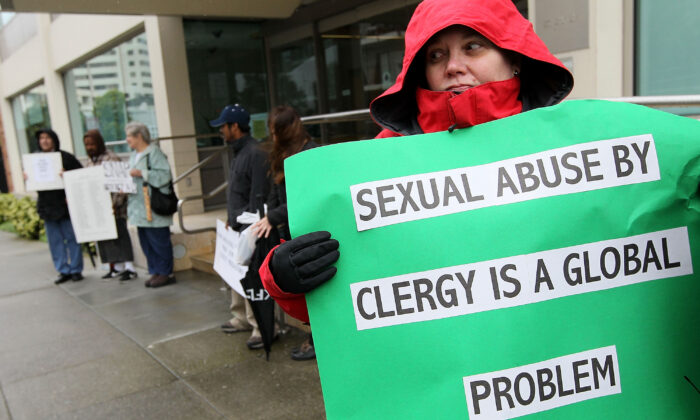Une manifestante tient une pancarte lors d'une manifestation avec des membres du groupe SNAP, le Réseau des survivants des personnes abusées par des prêtres, devant les bureaux de l'archidiocèse de San Francisco, à San Francisco, en Californie, le 29 mars 2010. (Justin Sullivan/Getty Images)