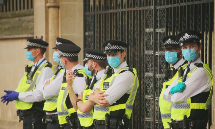 Des policiers se tiennent debout, portant des masques de protection contre la transmission du virus du PCC, à Londres le 9 septembre 2020. (Isabel Infantes/AFP via Getty Images)