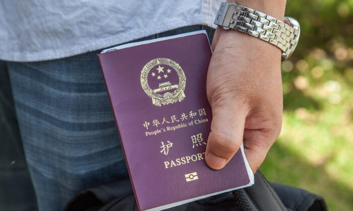Un ressortissant chinois tient à la main un passeport chinois, le 16 mai 2014. (Omar Havana/Getty Images)