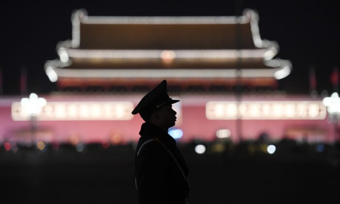 Un officier de police paramilitaire monte la garde sur la place Tiananmen après une session plénière de l'Assemblée populaire nationale dans le Palais de l'Assemblée du peuple adjacent, à Pékin, le 11 mars 2018. (Greg Baker/AFP via Getty Images)