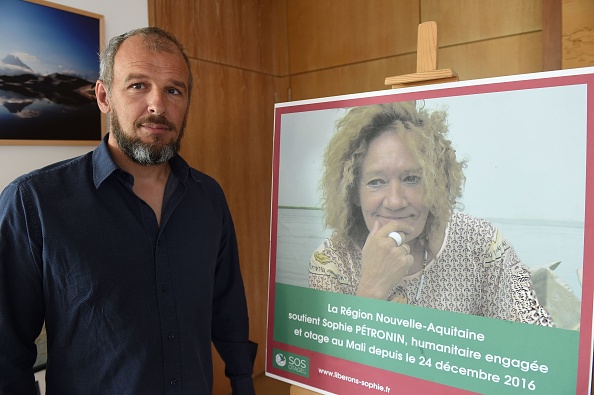 Sébastien Chadaud-Pétronin pose à côté d'une photo de sa mère française otage Sophie Pétronin.  (Photo :  MEHDI FEDOUACH/AFP via Getty Images)