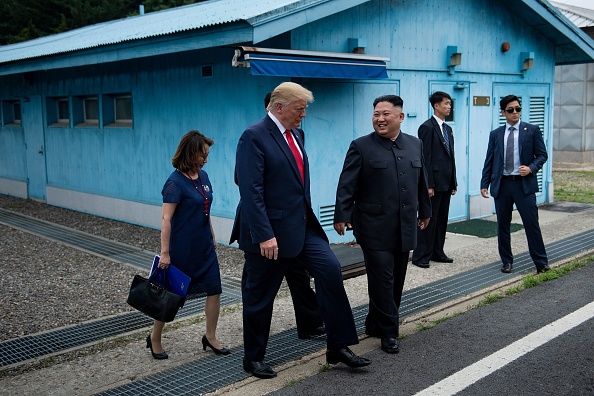 -Le dirigeant nord-coréen Kim Jong Un et le président américain Donald Trump marchent ensemble au sud de la ligne de démarcation militaire qui sépare la Corée du Nord et la Corée du Sud. Photo de Brendan Smialowski / AFP via Getty Images.