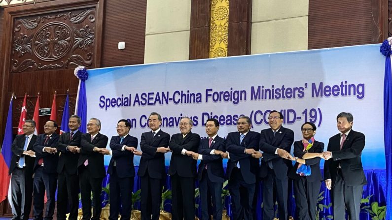 Lim Jock Hoi, le secrétaire général de l'ASEAN, et les ministres des affaires étrangères se serrent la main lors du sommet entre la Chine et l'ASEAN sur le Covid-19 à Vientiane, au Laos, le 20 février 2020. (Dene-Hern Chen/AFP via Getty Images)