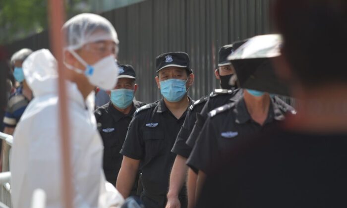 Des agents de sécurité font la queue pour subir des tests de dépistage du Covid-19 dans un centre de dépistage à Pékin le 30 juin 2020. (Greg Baker/AFP via Getty Images)