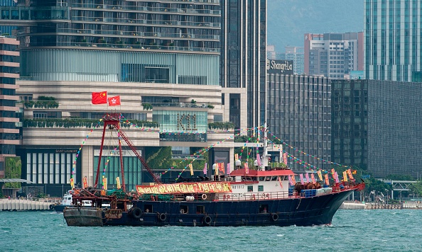 -Des navires de pêche portant des slogans et des drapeaux nationaux chinois naviguent en formation dans le port de Victoria lors de la fête nationale chinoise à Hong Kong le 1er octobre 2020. Photo par Jayne Russell / AFP via Getty Images.