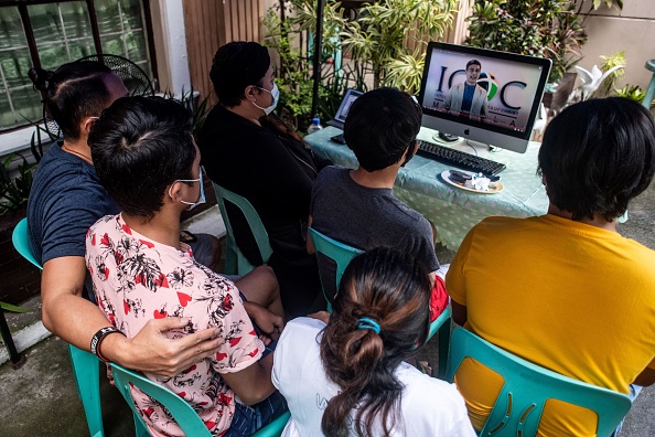 -Le 2 août 2020, Teejay Bagasbas et sa famille assistent à un service religieux en ligne à leur domicile à San Juan City, banlieue de Manille. Photo par Lisa Marie David / AFP via Getty Images.
