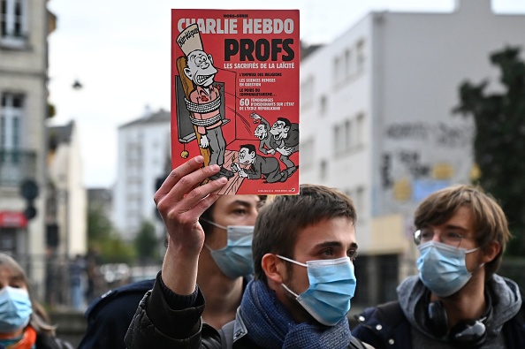 Couverture de Charlie Hebdo lors d'une manifestation à Rennes le 17 octobre 2020, un jour après que le professeur d'histoire Samuel Paty a été décapité par un tchétchène âgé de 18 ans à Conflans-Sainte-Honorine - L'enseignant avait montré à ses élèves des caricatures du prophète Mahomet de Charlie Hebdo. (Photo : AMIEN MEYER/AFP via Getty Images)
