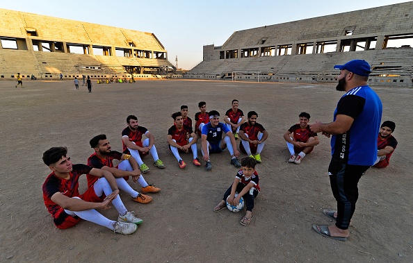 -Mohamed Fathi entraîneur du FC Al-Mossoul, s'entretient avec les joueurs de son équipe au stade ravagé al-Idara al-Mahalia, au nord de l'Irak le 22 octobre 2020. Photo par Zaid Al-Obeidi / AFP via Getty Images.