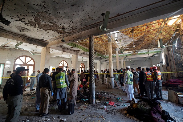 -Des responsables de la sécurité examinent le site d'une explosion dans une école religieuse de Peshawar au Pakistan, le 27 octobre 2020. Photo Abdul Majeed /AFP via Getty Images.