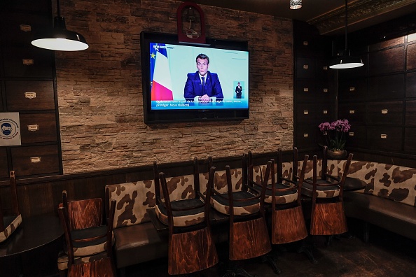 -Le président français Emmanuel Macron apparaît sur un téléviseur dans un bar à Paris le 28 octobre 2020 pour annoncer de nouvelles mesures visant à freiner la propagation de la pandémie de Covid-19. Photo de Stéphane De Sakutin / AFP via Getty Images.