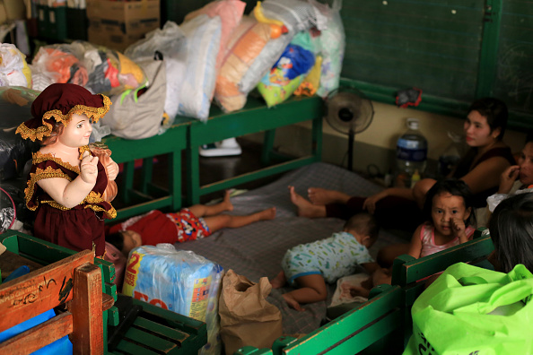 -Des familles avec leurs affaires se reposent dans un centre d'évacuation, au sud de Manille, le 31 octobre 2020, avant l'atterrissage du typhon Goni. Photo par Charism Sayat / AFP via Getty Images.