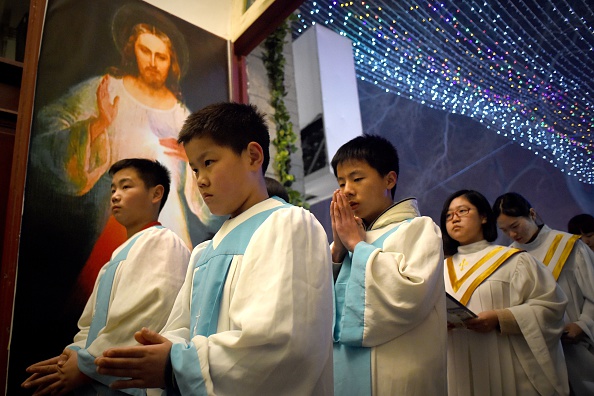 -De jeunes fidèles chinois assistent à la messe de la veille de Noël dans une église catholique de Pékin le 24 décembre 2015 alors que les chrétiens du monde entier se préparent à célébrer le jour saint. Photo Wang Zhao / AFP via Getty Images.