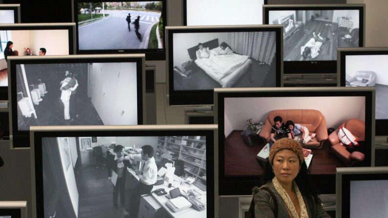 Une femme chinoise se tient à côté de vidéos montrant des violences domestiques et des ruptures de mariage lors d'une exposition à Shanghai, le 15 mars 2007. (Mark Ralston/AFP/Getty Images)
