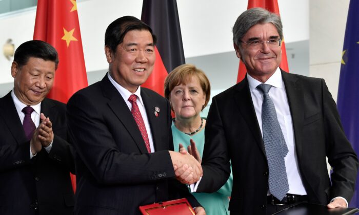 La chancelière allemande Angela Merkel (C) et le dirigeant chinois Xi Jinping (G) regardent le président de Siemens Joe Kaeser (D) serrer la main d'un partenaire commercial chinois lors d'une cérémonie de signature de contrats commerciaux germano-chinois à la Chancellerie à Berlin, le 5 juillet 2017. (John Macdougall/AFP via Getty Images)