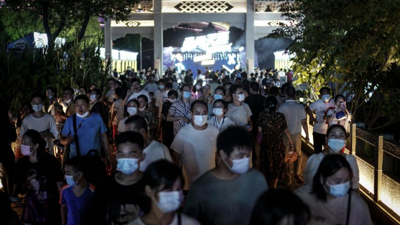 Des habitants portent des masques en se promenant à l'entrée du festival de la bière de Wuhan, dans la ville de Wuhan, province de Hubei, en Chine, le 21 août 2020. (Getty Images)