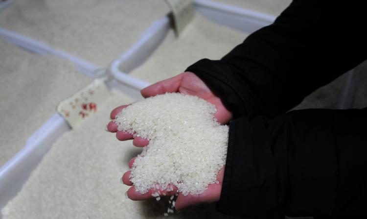 Une vendeuse prend du riz dans son étal sur un marché de Pékin. Depuis des décennies, des niveaux élevés de cadmium et d'autres métaux lourds toxiques polluent les cours d'eau chinois et, par l'irrigation, ils se sont retrouvés dans les rizières des villages. (Peter Parks/Getty Images)