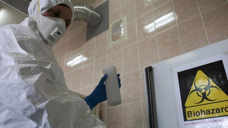 Un employé de laboratoire russe manipule un récipient qui contient la souche H1N1 du virus de la grippe porcine à Saint-Pétersbourg le 13 mai 2009. (Kirill Sirotyuk/AFP via Getty Images)