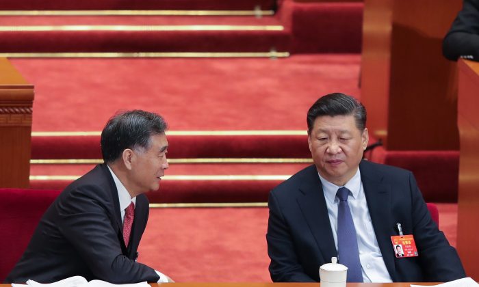 Le dirigeant chinois Xi Jinping (à droite) s'entretient avec le président de la Conférence consultative politique du peuple chinois Wang Yang (à gauche) lors de l'ouverture de la deuxième session du 13e Congrès national du peuple au Grand Hall du peuple le 5 mars 2019 à Pékin, en Chine. (Lintao Zhang/Getty Images)
