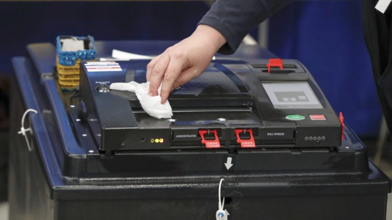 Une machine de vote est nettoyée lors des primaires du parti démocrate de l'Illinois à Chicago, Illinois, le 17 mars 2020. (Kamil Krzaczynski/AFP via Getty Images)