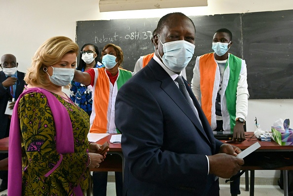 -Le président ivoirien Alassane Ouattara et son épouse Dominique Ouattara arrivent pour voter dans un bureau de vote à Abidjan le 31 octobre 2020, lors de l'élection présidentielle ivoirienne. Photo par Issouf Sanogo / AFP via Getty Images.