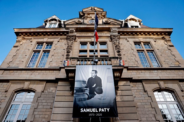 -Une affiche représentant le professeur de français Samuel Paty posée sur la façade de la mairie de Conflans-Sainte-Honorine, à 30kms au nord-ouest de Paris, le 3 novembre 2020, à la suite de la décapitation du professeur. Photo par Thomas Coex / AFP via Getty Images.