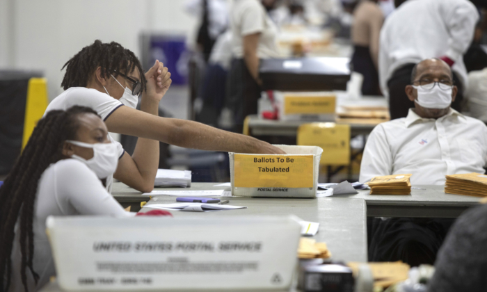 Un employé du département des élections de Détroit trie les bulletins de vote par procuration au Central Counting Board du centre TCF de Détroit, Michigan, le 4 novembre 2020. (Elaine Cromie/Getty Images)