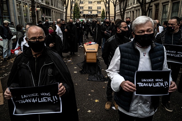 Restaurateurs, cuisiniers et commerçants, se rassemblent autour d'un cercueil, le 9 novembre 2020 devant la préfecture de Lyon, pour protester contre les mesures prises par le gouvernement pour fermer leurs établissements afin de freiner la propagation de la pandémie du COVID-19.  (Photo : JEFF PACHOUD/AFP via Getty Images)