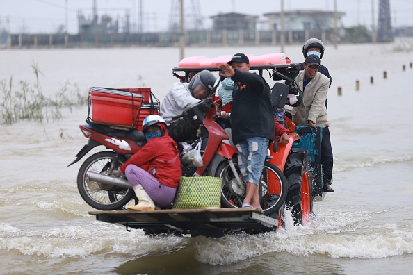 -Les habitants sont transportés sur un chariot élévateur vers la terre ferme à travers les eaux de crue provoquées par les fortes pluies du typhon Vamco, le 15 novembre 2020.  Photo de Huy Thanh / AFP via Getty Images.