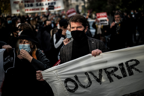 Image d'illustration : un homme portant une banderole dans une manifestation de commerçants à Lyon le 16 novembre. (JEFF PACHOUD/AFP via Getty Images)